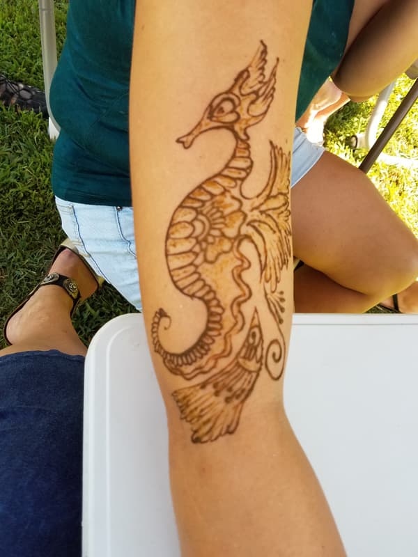 Large henna seahorse design running the length of a forearm