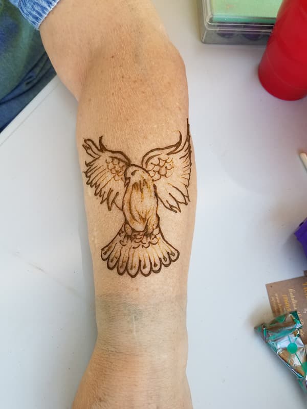 Henna eagle with outstretched wings drawn on a forearm