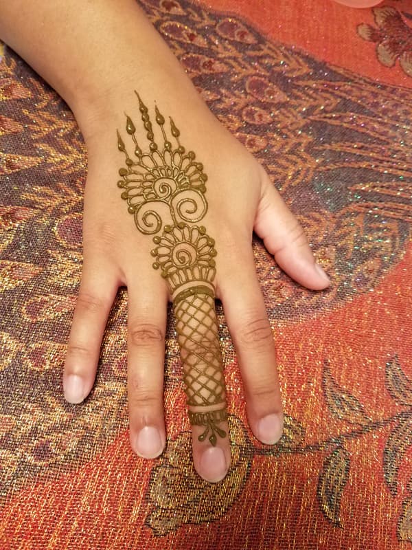 Henna fan design with a lattice-wrapped finger on the back of a hand
