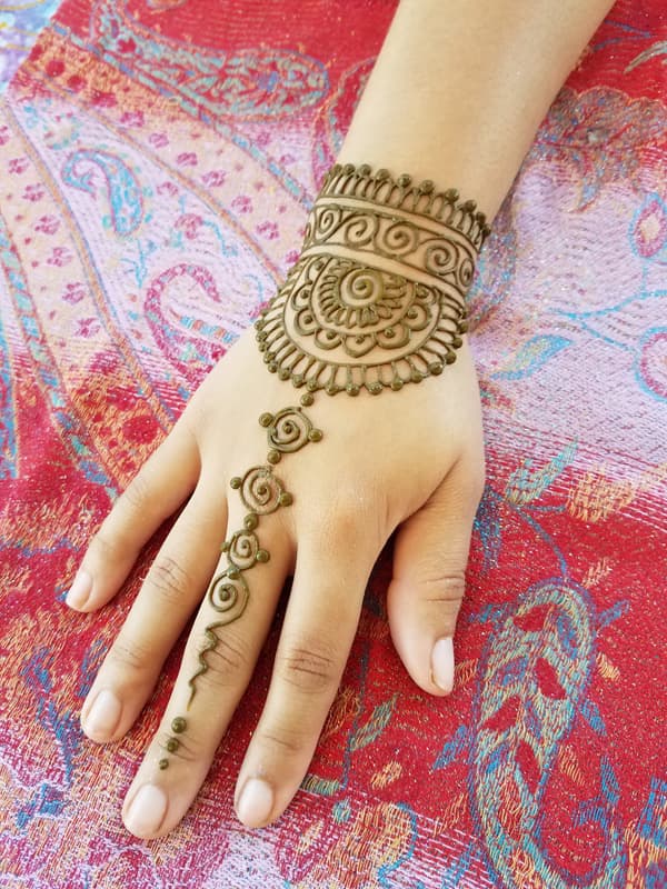 Henna bracelet cuff with a spiral pendant chain linking to one finger