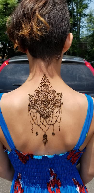 Catalina LaPointe applying a custom henna design to a client