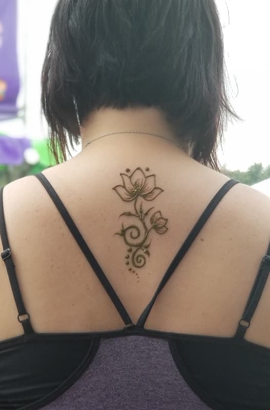 Henna lotus and bud design between the shoulder blades